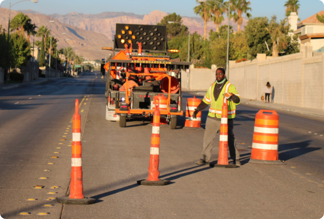 Traffic control worker placing traffic cones and barrels